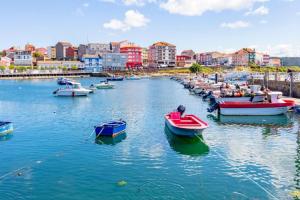 a group of boats docked in a harbor with buildings at Casa roja in Camariñas +4 photos
