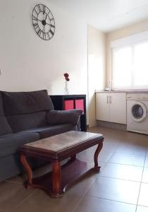a living room with a couch and a clock on the wall at Casa roja in Camariñas