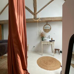 ein Wohnzimmer mit einem Vorhang und einem Tisch in der Unterkunft Gîte verveine bain nordique jacuzzi l écrin de verdure chinon in Ligré