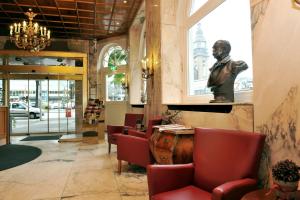 un restaurante con sillas rojas y una estatua en la pared en Hotel Fürst Bismarck, en Hamburgo