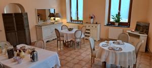 comedor con 2 mesas, sillas y espejo en La Vernassonne, en Alzonne