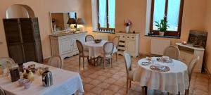 a dining room with two tables and chairs and a mirror at La Vernassonne in Alzonne