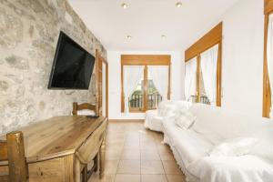 Casa ponet في سولسونا: غرفة معيشة مع كنبتين بيضاء وتلفزيون