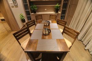 a wooden table with two tea pots on top of it at CATALEYA Home Stay in Kotagiri