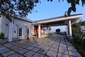 a stone walkway leading to a white house with a pergola at CATALEYA Home Stay in Kotagiri