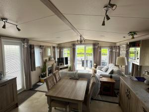 Luxury Lake District Holiday Home-Sleeps 4 في كوكيرماوث: غرفة معيشة مع طاولة وأريكة