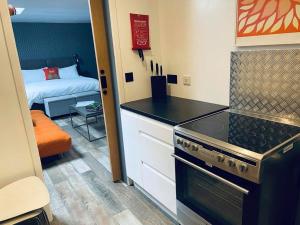 cocina con fogones y habitación con cama en An Leti @ Goonwinnow Farm, en Newquay