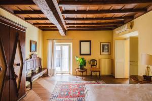 a bedroom with yellow walls and a wooden ceiling at YourSuiteRome in Rome