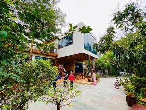 a house with people walking in front of it at Hòa Hoa Villa in Yên Ha