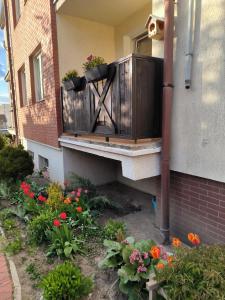 a balcony of a house with flowers on it at Apartament 25 Mikołajki in Mikołajki