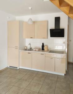 a kitchen with white cabinets and a sink at Apartamenty Adrenja in Rowy
