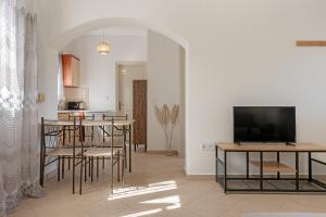 a living room with a television and a table and chairs at Spiros house in Svoronata