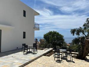 a patio with chairs and a table on the side of a house at Villa Thomas in Dhërmi