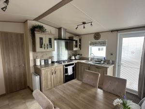 Luxury Lake District Holiday Home-Sleeps 4 في كوكيرماوث: مطبخ مع طاولة خشبية وغرفة طعام