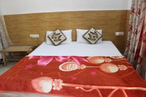 a bed with a red blanket and pillows on it at Hotel Heritage High in Udaipur