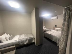 um quarto de hotel com duas camas e uma janela em Arena Deluxe & Spa em Szeged