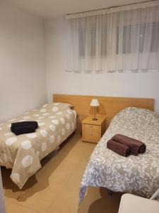 a bedroom with two beds and a lamp and a window at Luxury Ground Floor Apartment at Golf Resort Condado de Alhama with Private Garden & Pools in El Romero