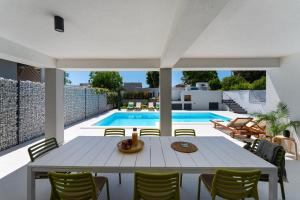 a patio with a table and chairs and a pool at D Marine villa in Bibinje
