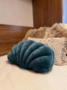 una almohada azul sobre una cama en EDEN GARDEN b&b en Ponferrada