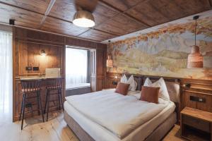 a bedroom with a large bed and a painting on the wall at Latemar - Hotel Suites Spa in Soraga +178 photos