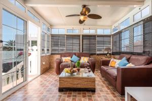 a living room with a couch and a ceiling fan at Villa Naranja with private heated pool, sea views, air conditioning, terrace, ITV and BBC channels, Wifi in Callao Salvaje