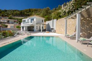 a villa with a swimming pool and a house at Villa Kenza in Lygia