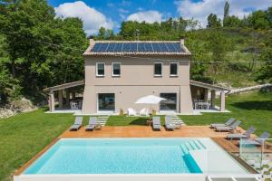 uma casa com piscina e uma casa com painéis solares em Villa Gea 12 em Fermignano