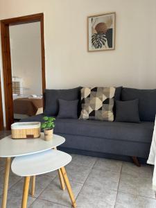 um sofá azul numa sala de estar com uma mesa em Starry Coast Apartments em Nea Poteidaia