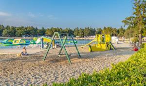 a group of playground equipment on a beach at Eurocamp Mobile Homes at Campsite Valkanela in Funtana