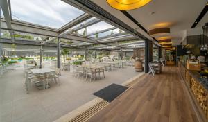 a restaurant with white tables and chairs and windows at Eurocamp Mobile Homes at Campsite Valkanela in Funtana