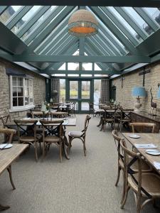 um restaurante com mesas e cadeiras e um tecto de vidro em White Hart Ufford- Stamford em Ufford