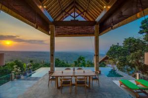 an outdoor dining area with a table and chairs and a view at Sanglung Villas & Suites in Kubutambahan