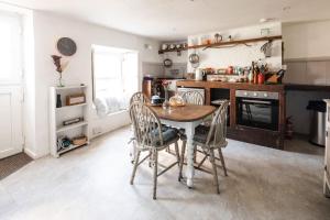 a kitchen with a table and chairs in a room at Charming Cornish Cottage, Portreath, Dogs Welcome in Redruth