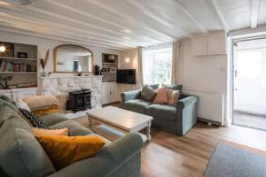 a living room with two couches and a fireplace at Charming Cornish Cottage, Portreath, Dogs Welcome in Redruth