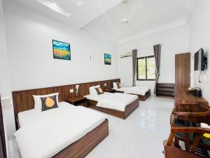 een hotelkamer met 2 bedden en een televisie bij KL Retreat Hotel in Thanh Hóa
