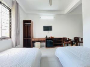 een slaapkamer met een bed, een bureau en een televisie bij KL Retreat Hotel in Thanh Hóa