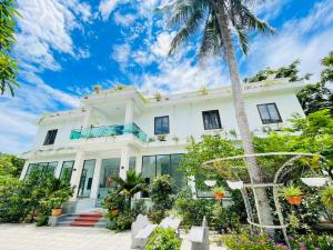 biały dom z palmą w obiekcie KL Retreat Hotel w mieście Thanh Hóa