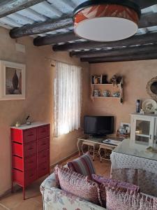 sala de estar con sofá y cómoda roja en La Casita, en Cazalla de la Sierra