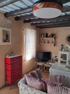 ein Wohnzimmer mit einem Sofa und einer roten Kommode in der Unterkunft La Casita in Cazalla de la Sierra