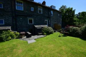 a large brick building with a grill in the yard at Myrtle Cottage in Chapel Stile