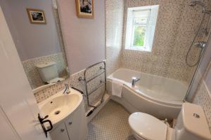 a bathroom with a sink and a toilet and a bath tub at Myrtle Cottage in Chapel Stile +11 photos