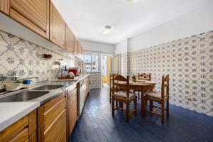 a kitchen with a sink and a table with chairs at Apartamento Praia da Rocha in Portimão