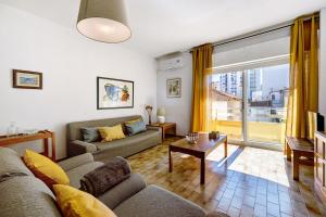 a living room with a couch and a large window at Apartamento Praia da Rocha in Portimão