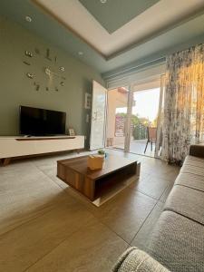sala de estar con sofá y TV en Akrotiri Luxury Suites en Trápeza