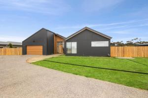 a black house with a large yard at Casa del Candelabra - Light-Filled Luxury Retreat Minutes from Town in Bellbrae