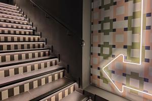 an empty stairs with a neon sign on the wall at Aparthotel AMMI Nice Lafayette in Nice