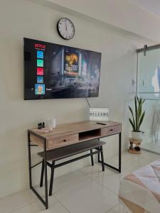 a desk in a room with a clock on a wall at Lake View Wind SMDC Tagaytay in Tagaytay