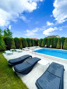 una piscina con 2 tumbonas y sillas en un patio en Riviera -Adults Only, en Rewal
