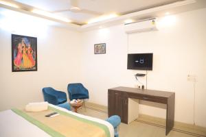 a room with a bed and a desk and a tv at Fortune Home Service Apartment 3Bhk , D-198 Saket in New Delhi