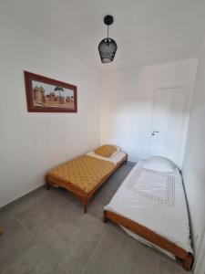 a room with two beds and a picture on the wall at Beaux Souvenirs in Boujan-sur-Libron